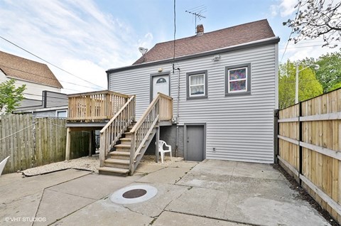 a gray house with a yard and a deck