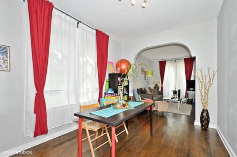 a living room with red curtains and a dining room table