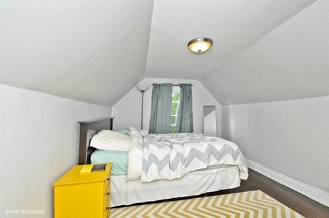 a bedroom with a bed and a yellow dresser