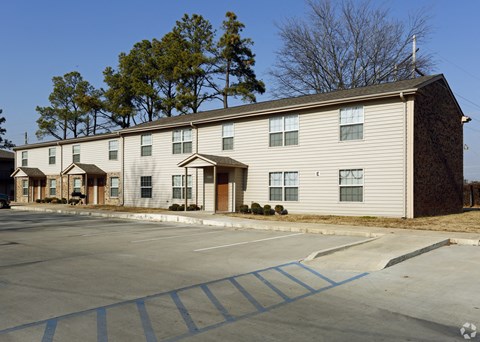 an apartment building on the corner of a parking lot