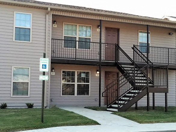 an apartment building with stairs and a porch