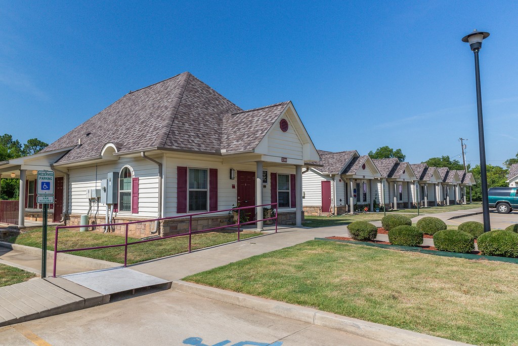 a row of houses in a neighborhood with a sidewalk and grass