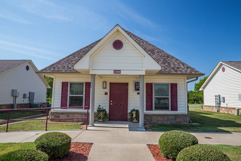 a house with a red door and a sidewalk in front of it