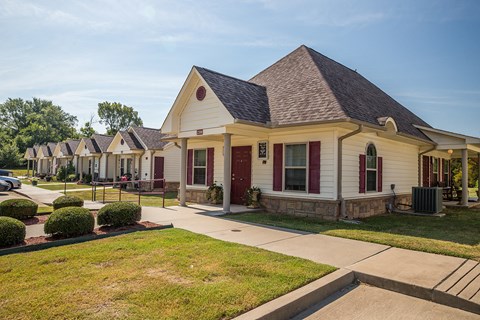a row of houses in a neighborhood with a sidewalk and grass