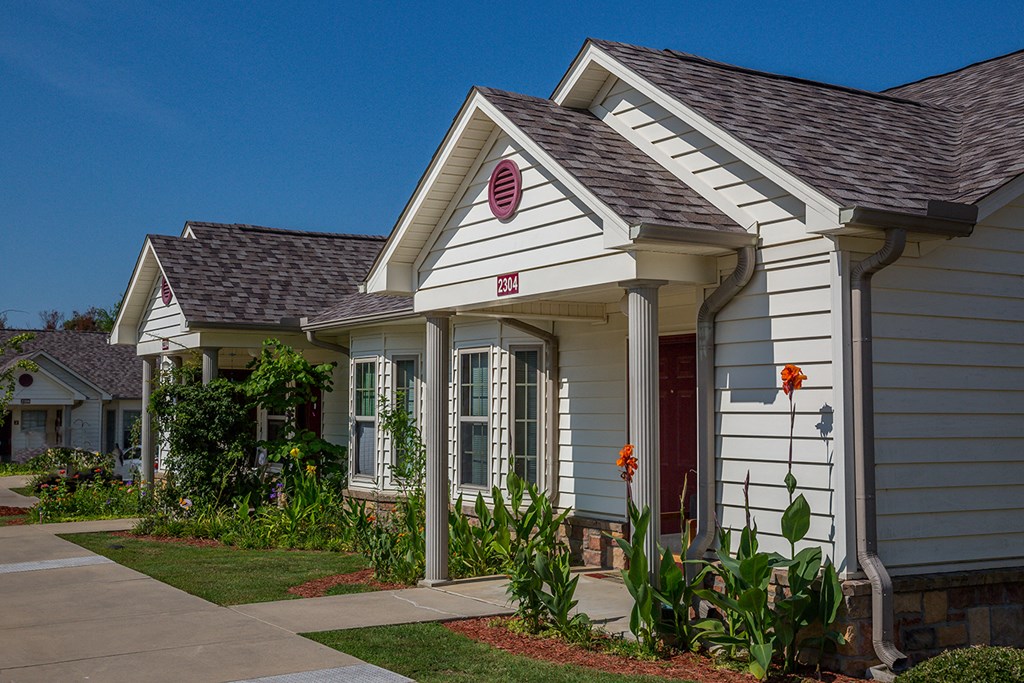 a white house with a sidewalk in front of it