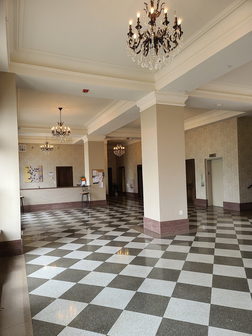 a large lobby with a checkered floor and a chandelier