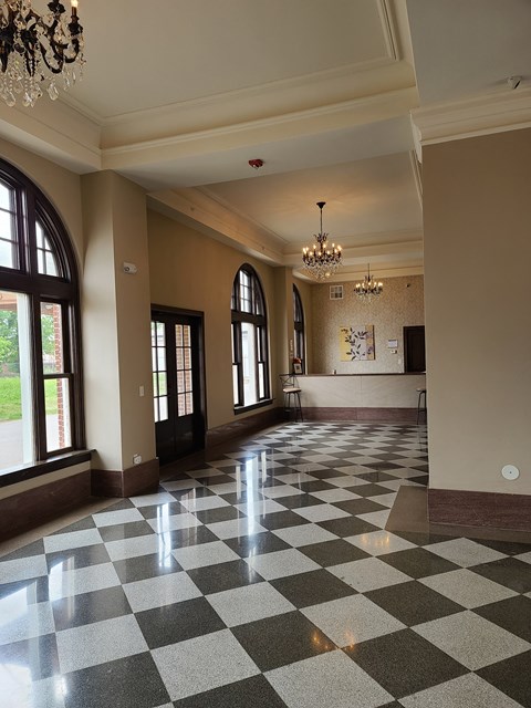 a lobby with a checkered floor and a chandelier