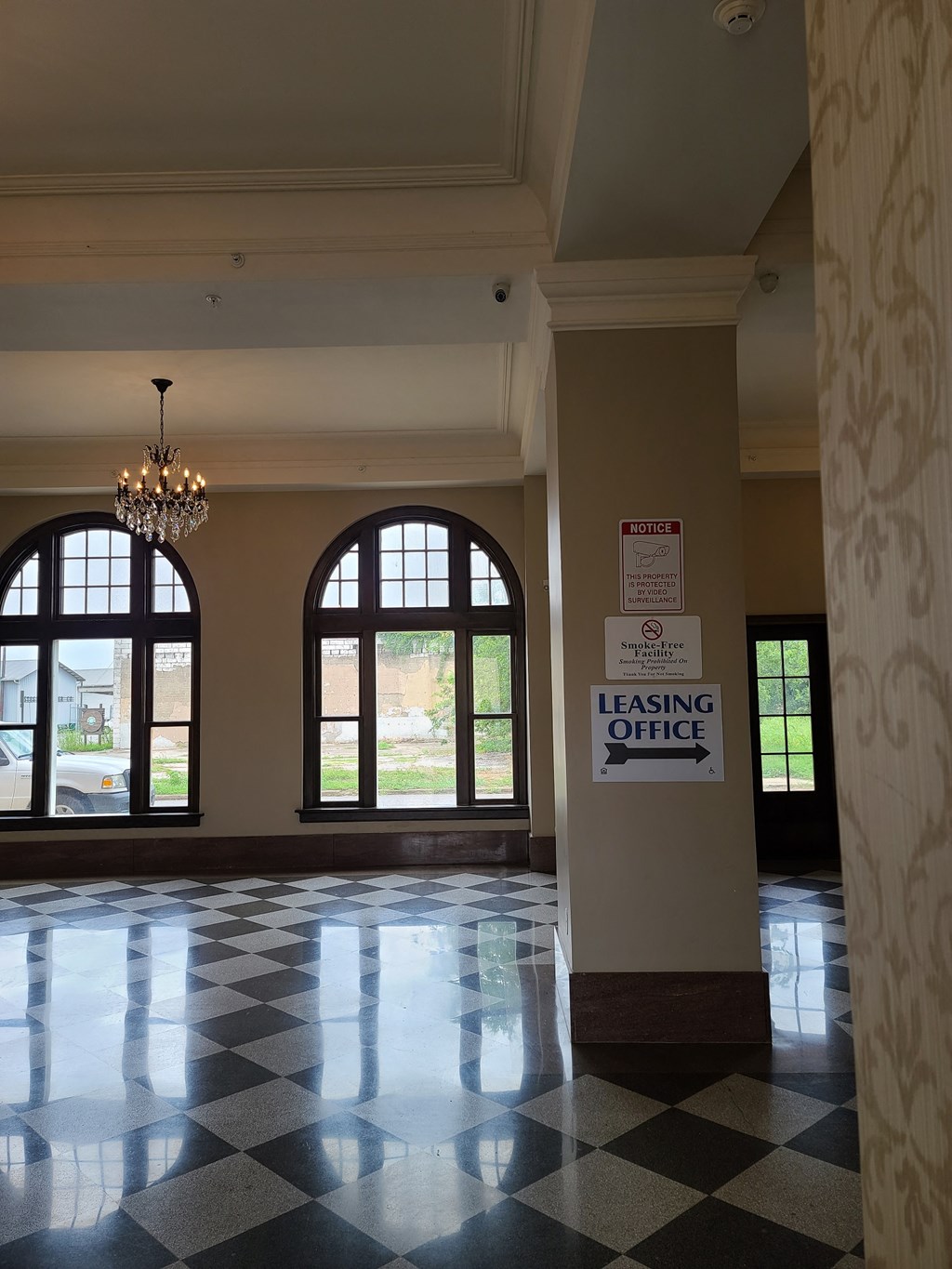 a lobby with large windows and a leasing office sign