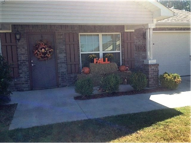 a front porch of a house with a fall sign in the window