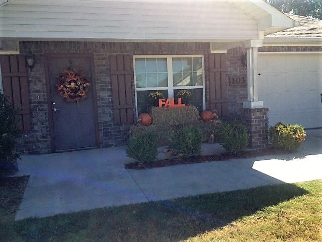 a front porch of a house with a fall sign in the window