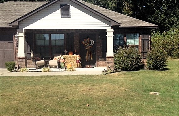a group of people sitting on the porch of a house