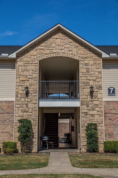 the front of a brick building with a balcony