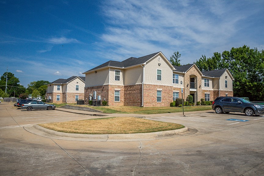 an empty parking lot in front of an apartment building