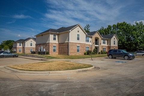 an empty parking lot in front of an apartment building
