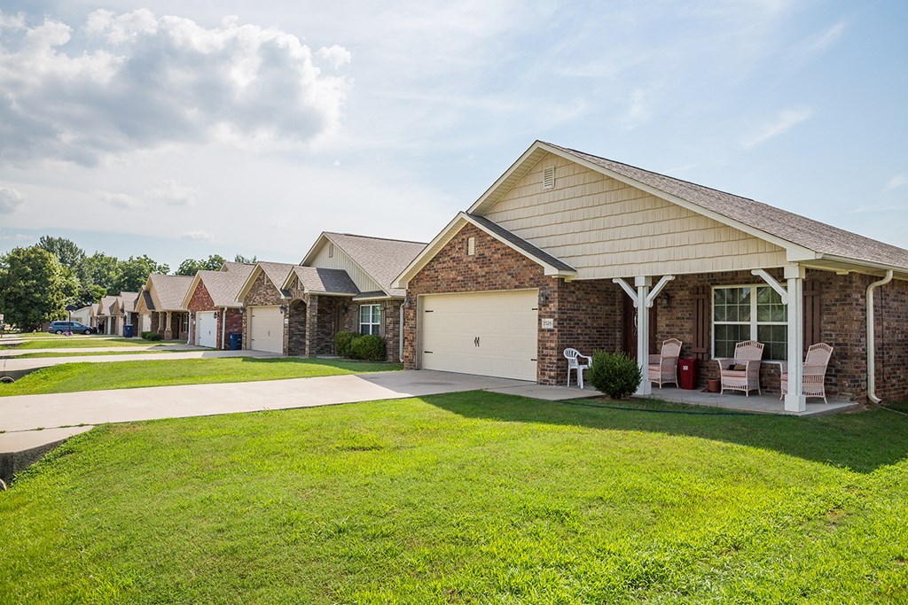 a row of houses with lawns and chairs in front of them