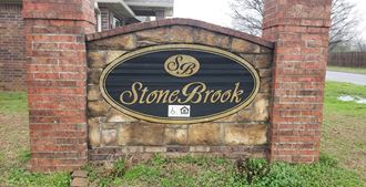 a stone brick sign in front of a building