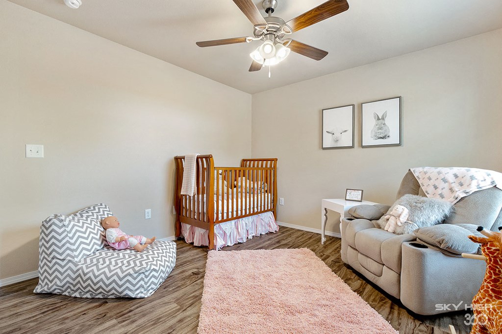 an open living room with a baby crib and a couch