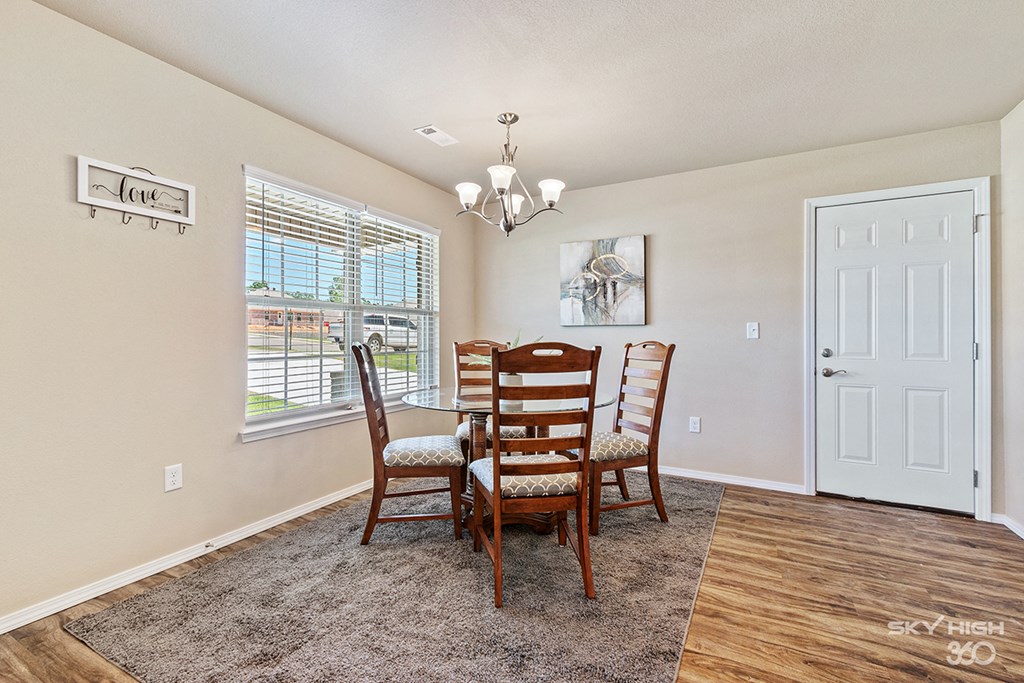 a dining room with a table and chairs and a window