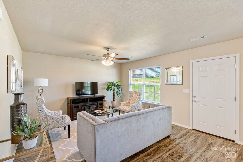a living room with a couch and a ceiling fan
