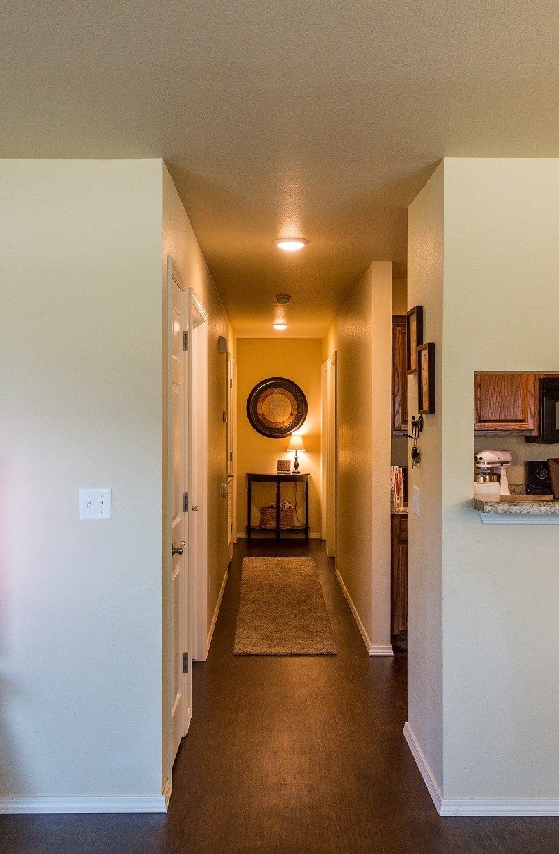 a long hallway with a rug and a mirror on the wall