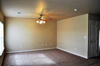 a empty room with a ceiling fan and a door