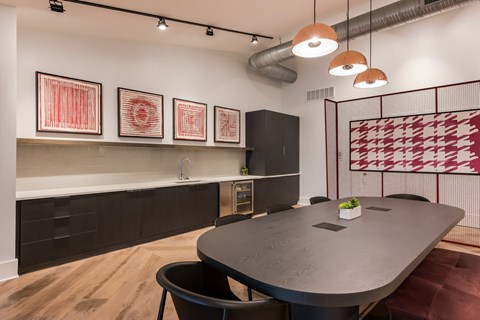 A modern dining room with a black table and chairs.