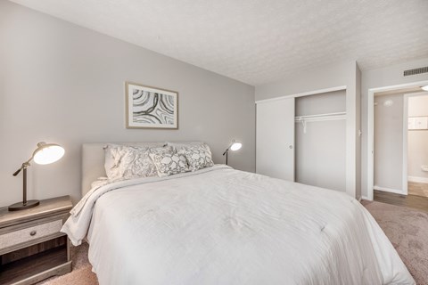 A bedroom with a large bed and a painting on the wall.
