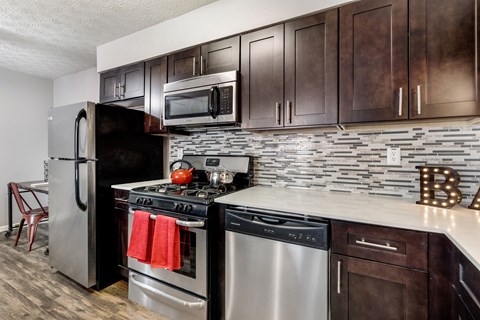 A kitchen with dark brown cabinets and a white countertop.