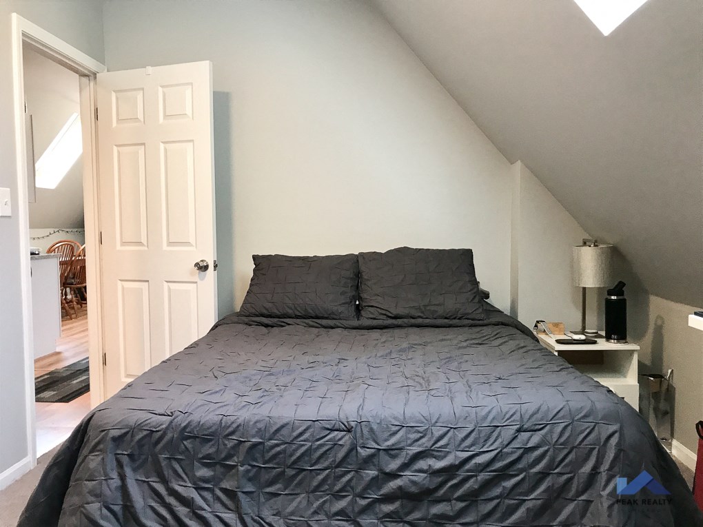 a bedroom with a bed and a door to a bathroom
