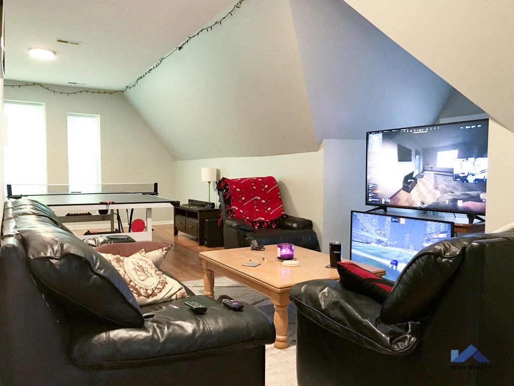 a living room with leather couches and a flat screen tv