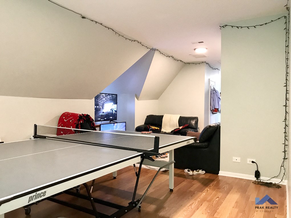a living room with a ping pong table and a tv