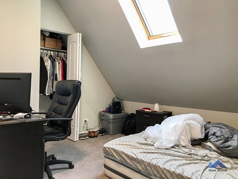 a room with a bed and a desk and a closet