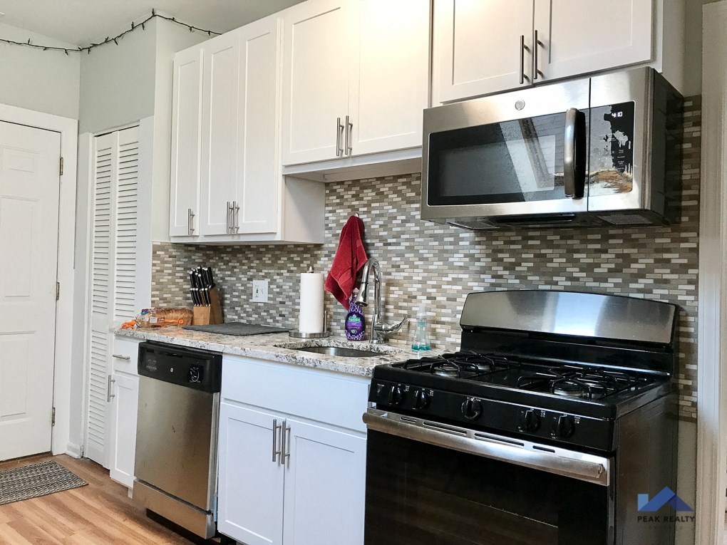 a kitchen with white cabinets and a stove and a microwave