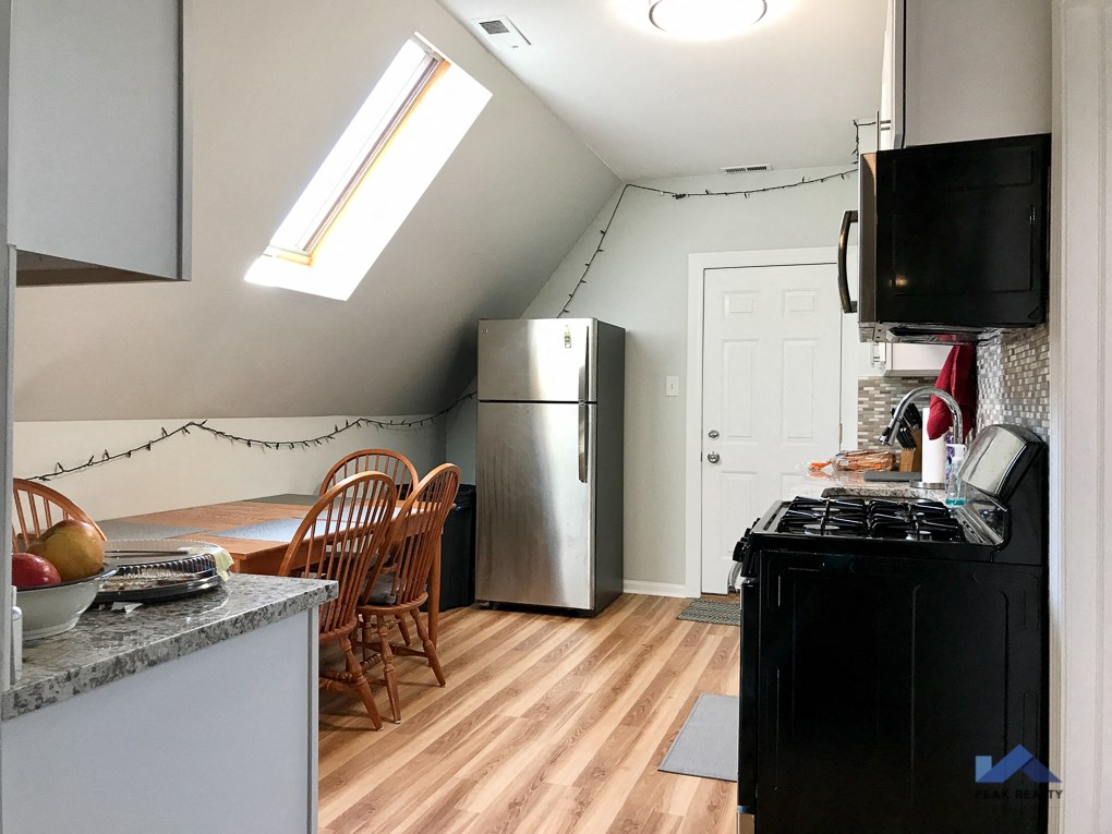a kitchen with a refrigerator and a table and chairs