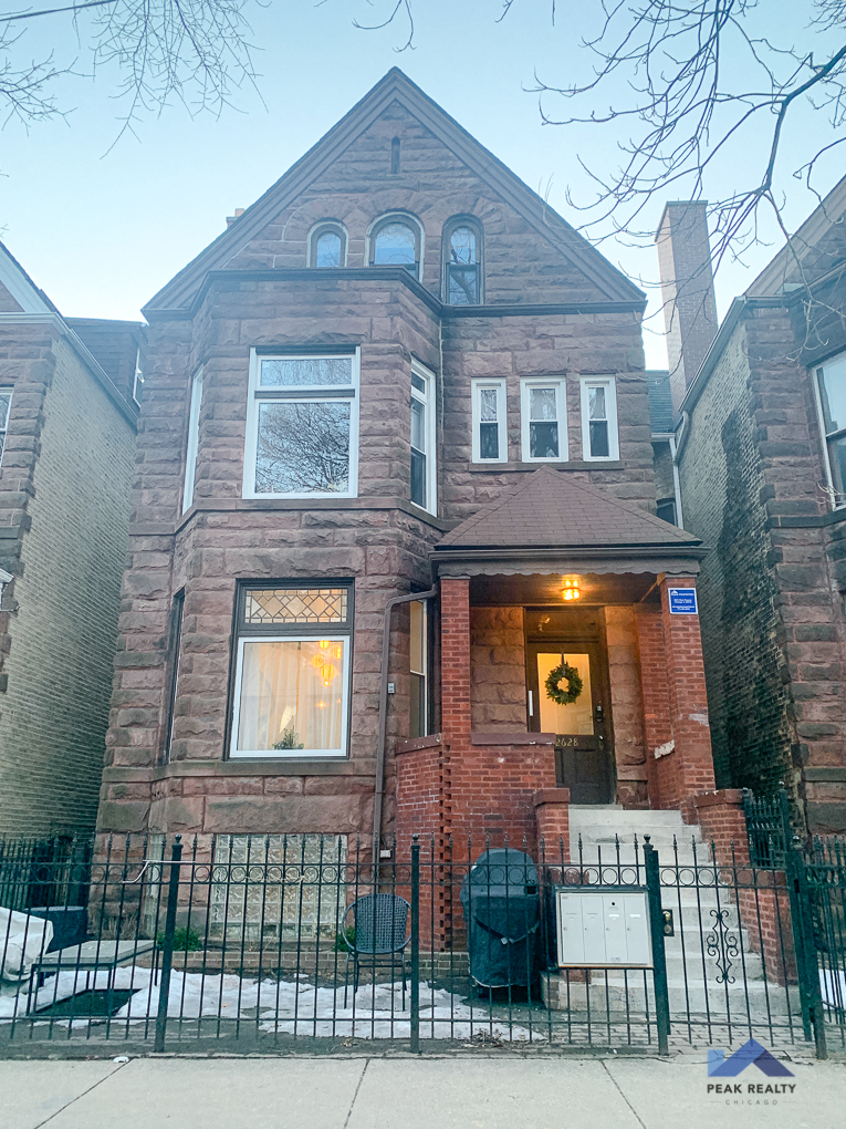 a brick house with a fence in front of it