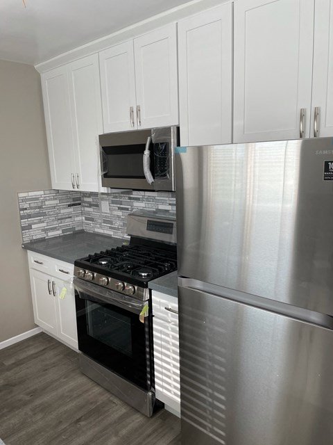 a kitchen with stainless steel appliances and white cabinets