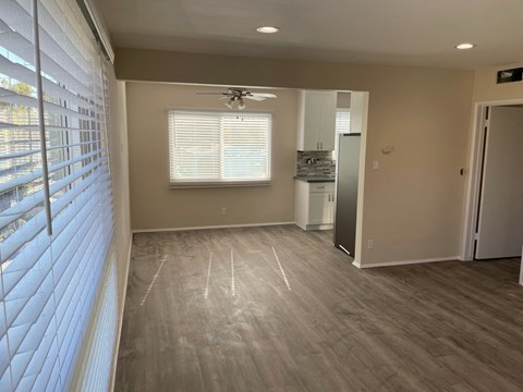 a living room with wood floors and a ceiling fan
