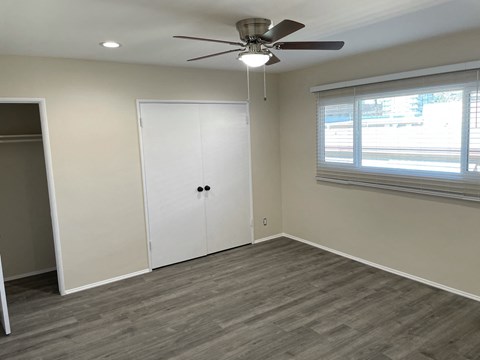 a bedroom with a ceiling fan and a closet