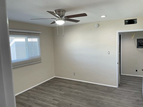a living room with a ceiling fan and a window