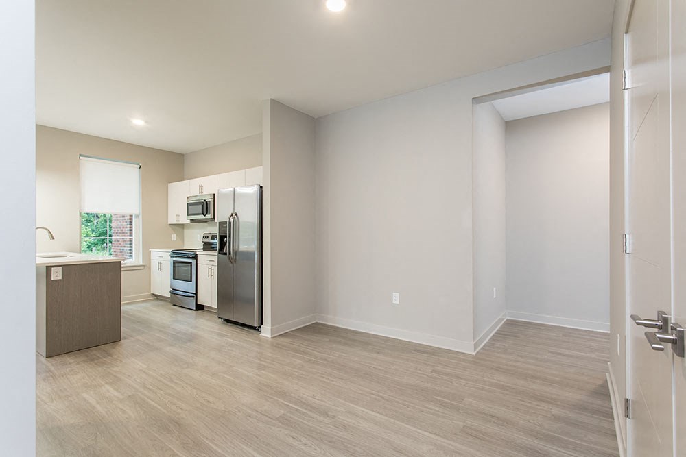 an empty kitchen with a stainless steel refrigerator and stove