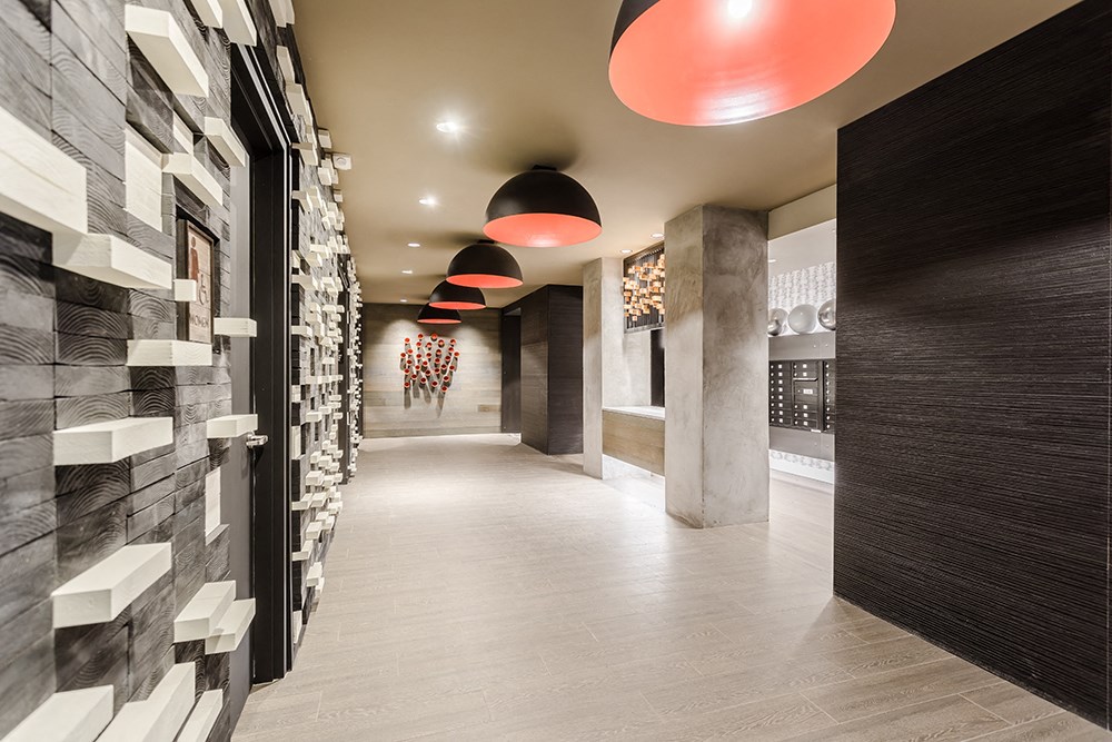 a long hallway with black and white tiles on the wall and a long walkway