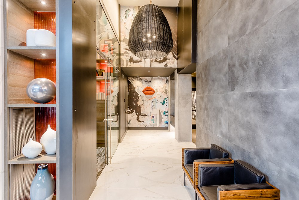 a hallway with a pendant light and chairs and a mural on the wall