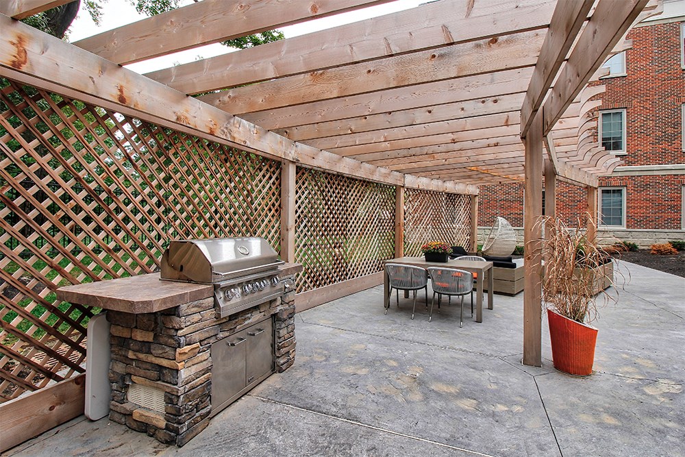 a backyard with a barbecue grill and a patio with a table and chairs