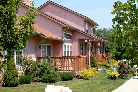 a pink house with a wooden deck in front of it