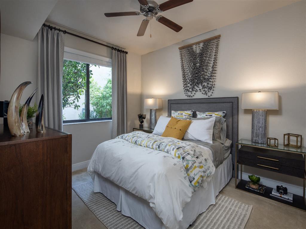bedroom with large window and ceiling fan