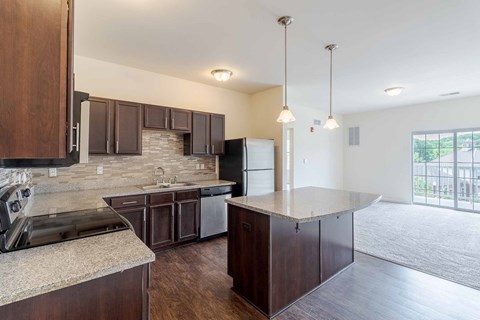 A kitchen with dark wood cabinets and granite countertops.