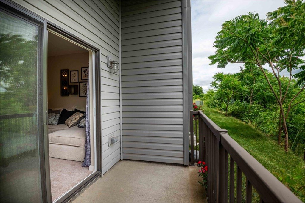 a balcony with a couch and a door to a living room