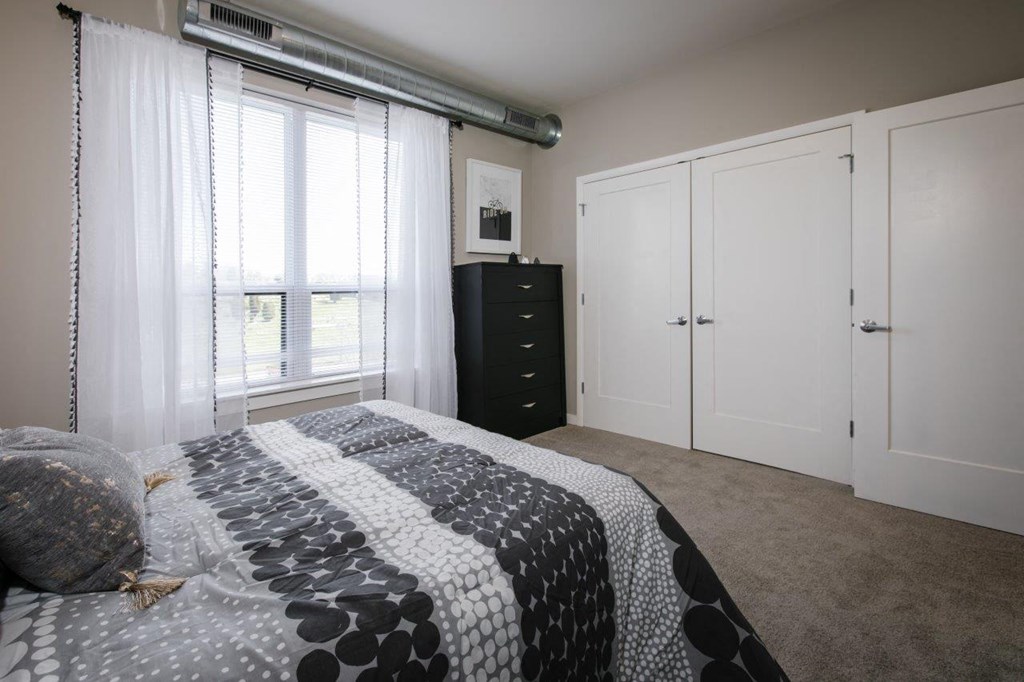 a bedroom with a large bed and white closets