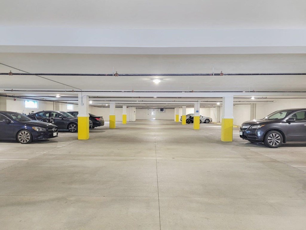 a parking garage filled with cars and yellow pillars