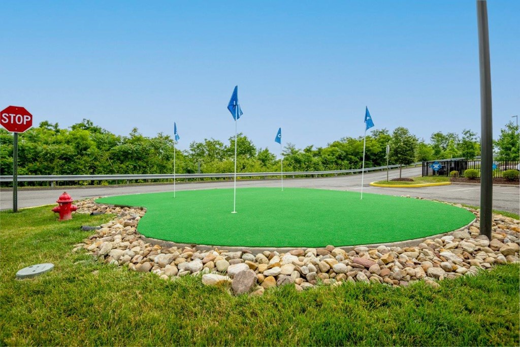 a mini golf course in a park with flags and a stop sign